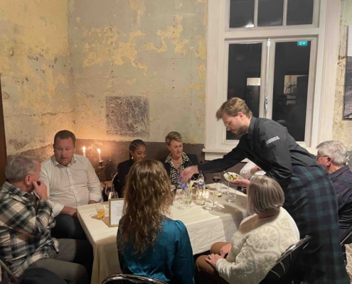 Wilddiner bij kaarslicht in het bagagedepot, een kok serveert aan tafel